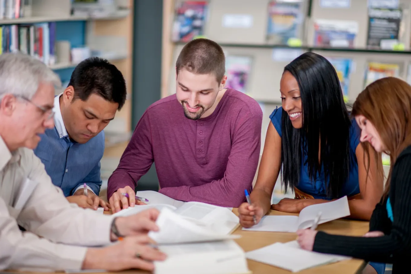Five teachers gathered around a table